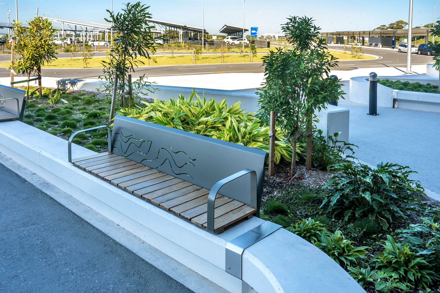 Custom plinth-fixed seat with perforated backrest in Monument, Jarrah battens and Woodland Grey frame.