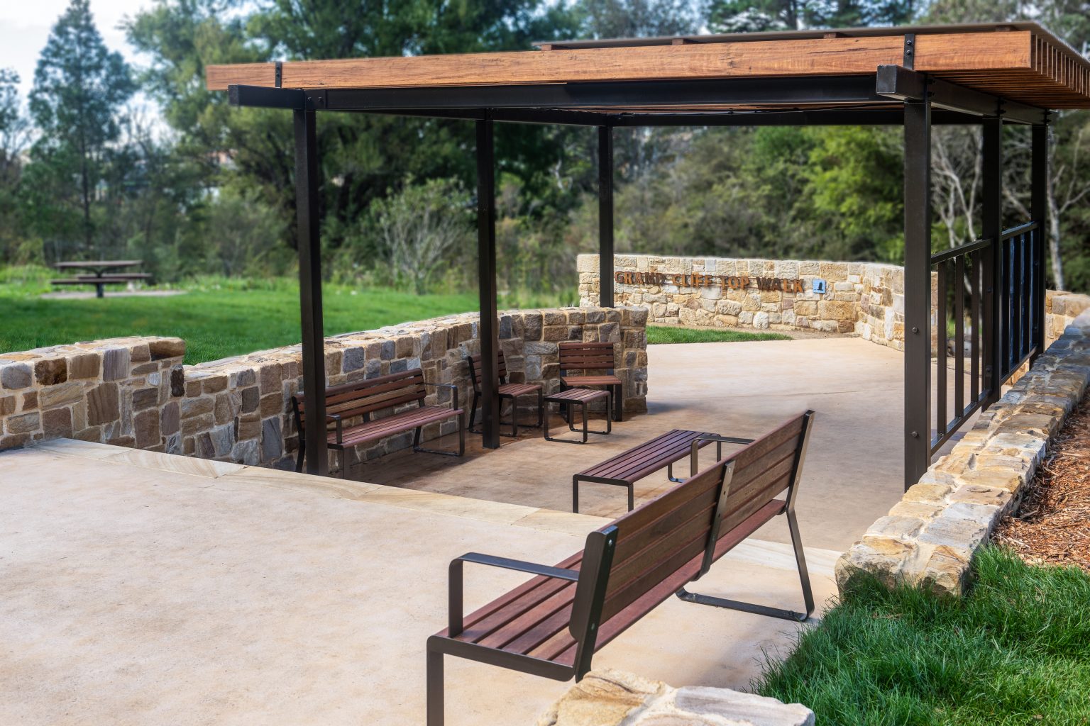 Linea Seat (LIS10) and Linea Bench (LIB6) with Spotted Gum hardwood battens, Textura Dark Bronze frame.