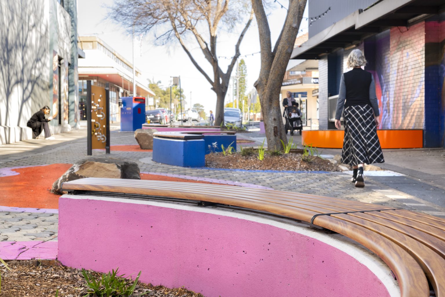 Linea Curved Bench (LIB6-C) plinth-fixed, in aluminium woodgrain Spotted Gum battens, Textura Monument frame.