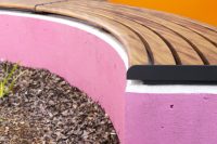 Linea Curved Bench (LIB6-C) plinth-fixed, in aluminium woodgrain Spotted Gum battens, Textura Monument frame.