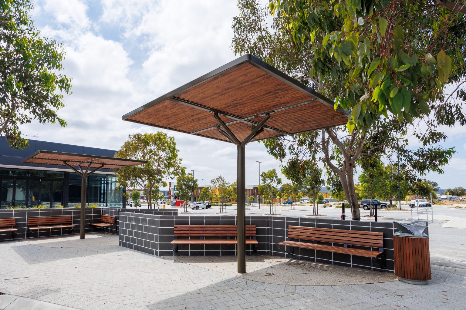ChillOUT Tree with aluminium spotted gum louvres and duratec eternity bronze trunk, Linea wall mounted seats in aluminium spotted gum and charcoal frame