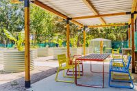 Piatto Chairs in Brilliant Yellow, Lobster Red and Bondi Blue. Linea Table in Lobster Red frame with aluminium woodgrain battens in Spotted Gum