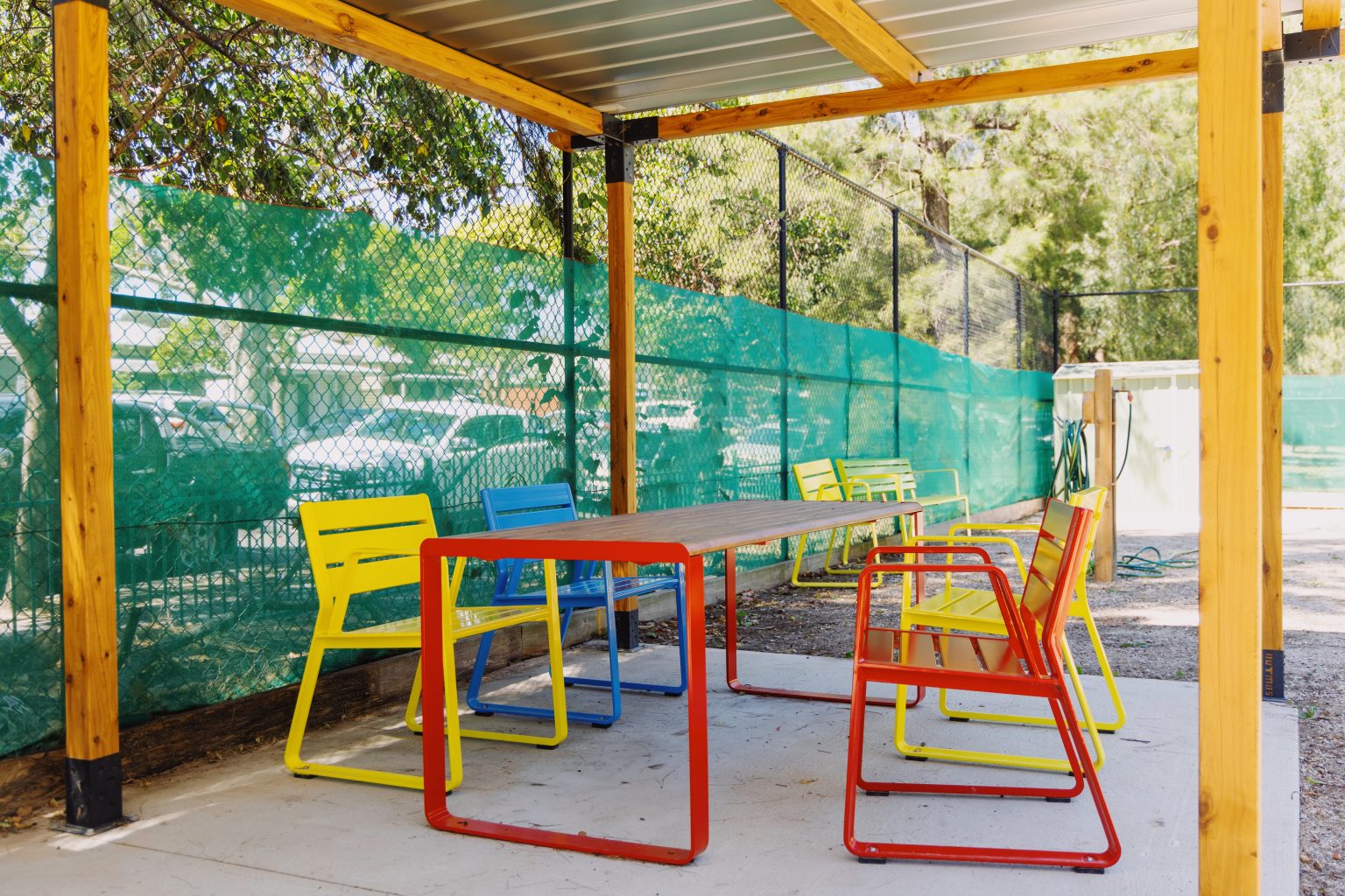 Piatto Chairs in Brilliant Yellow, Bondi Blue and Lobster Red. Linea Table in Lobster Red frame with aluminium woodgrain battens in Spotted Gum