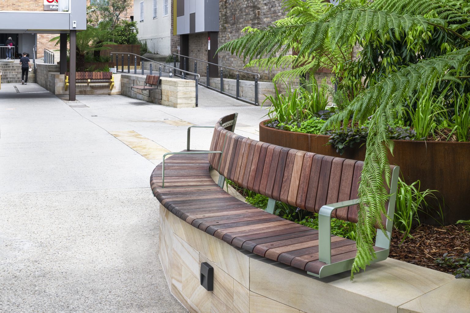 Curved Linea VT Seat (LVS10-C) 4000mm, Plinth mounted with Jarrah Hardwood battens and Pale Eucalypt Satin frame