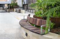Curved Linea VT Seat (LVS10-C) 4000mm, Plinth mounted with Jarrah Hardwood battens and Pale Eucalypt Satin frame