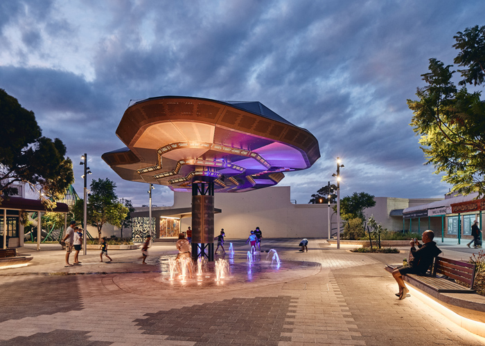 Aria Seat (CMA1), plinth-fixed. Eco-certified hardwood battens, Textura Woodland Grey frames. Hovering Earth Canopy by iredale pederson hook