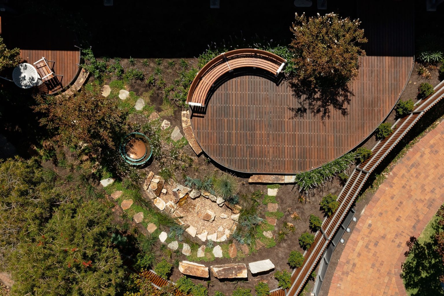 Aerial view of garden with Linea Curved Seats in Textura Surfmist, Wood Without Worry battens in Spotted Gum.