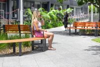 Curved and straight Linea Seats and Benches with frames in Textura Monument, battens in Bistro Orange and aluminium woodgrain Spotted Gum.