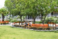 Curved and straight Linea Seats and Benches with frames in Textura Monument, battens in Bistro Orange and aluminium woodgrain Spotted Gum.