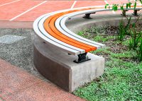 Mall Curved Slim Bench (CMM8-C) plinth-fixed, Textura Silver and Sensation Orange battens, Charcoal frame.