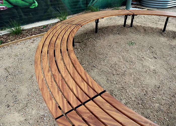 Mall Curved Slim Benches, battens in aluminium woodgrain Spotted Gum, frames in Night Sky.