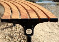 Mall Curved Slim Bench, battens in aluminium woodgrain Spotted Gum, frames in Night Sky.