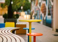 Mall Curved Slim Bench (CMM8-C) with aluminium Spotted Gum battens, Textura Monument frame. With Cafe Macchiato Table and Stool in Brilliant Yellow, Bondi Blue and Sensation Orange.