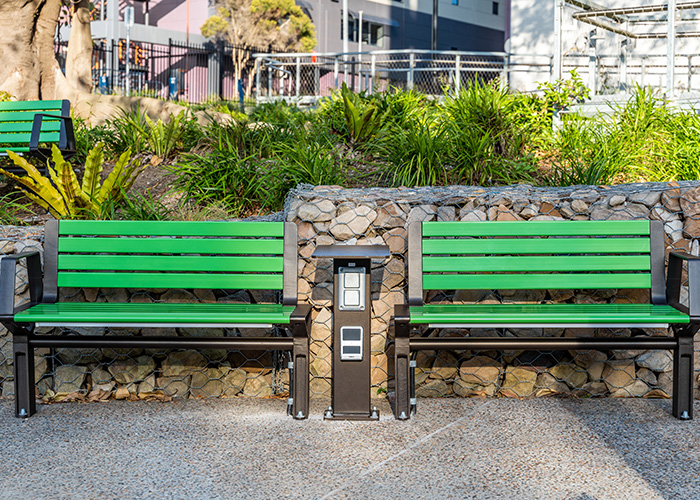 Aria Seat (CMA1, 1200mm) with Viper Green battens, Textura Dark Bronze frame. Custom charging table.