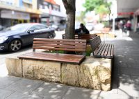 Linea Seat (LIS10, 1500mm) plinth-fixed with aluminium woodgrain Bush Cherry battens, Monument frame.