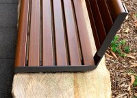 Linea Seat (LIS10, 1500mm) plinth-fixed with aluminium woodgrain Bush Cherry battens, Monument frame.