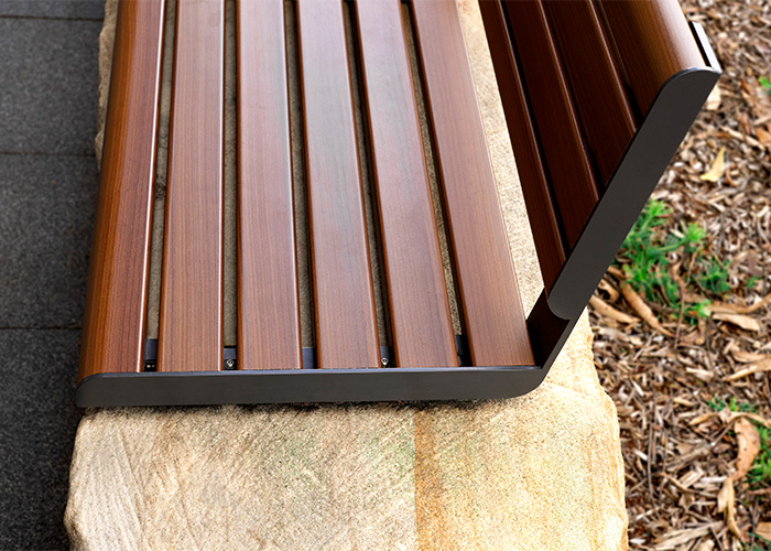 Linea Seat (LIS10, 1500mm) plinth-fixed with aluminium woodgrain Bush Cherry battens, Monument frame.