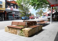 Linea Seat (LIS10, 1500mm) plinth-fixed with aluminium woodgrain Bush Cherry battens, Monument frame.