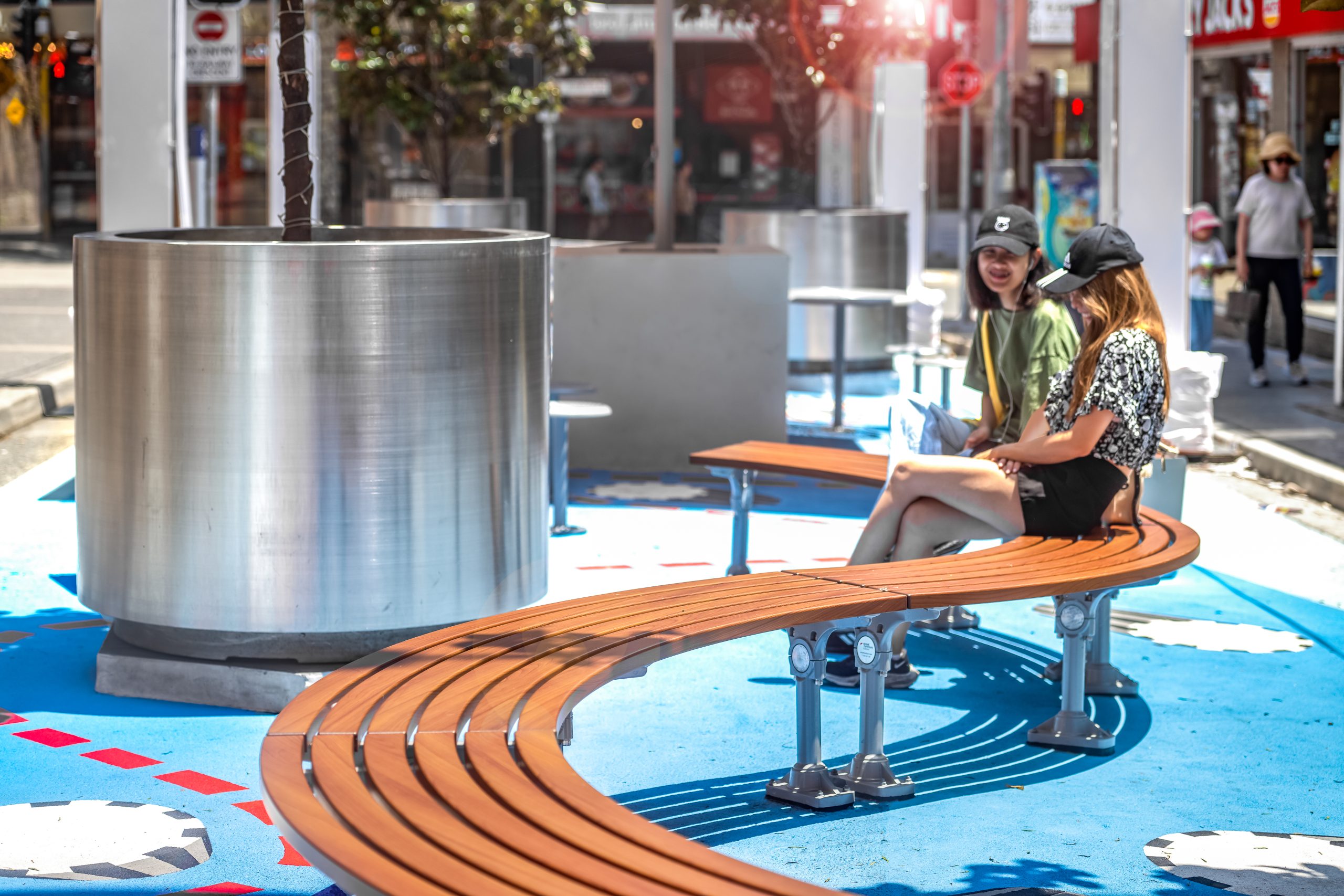 Mall Curved Slim Bench (CMM8-C) with aluminium Bush Cherry battens, Palladium Silver frame.
