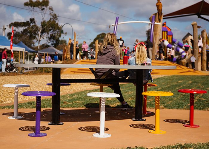 Custom oval tables feature an eaglehawk design, paired with 80 colourful Cafe Stools.