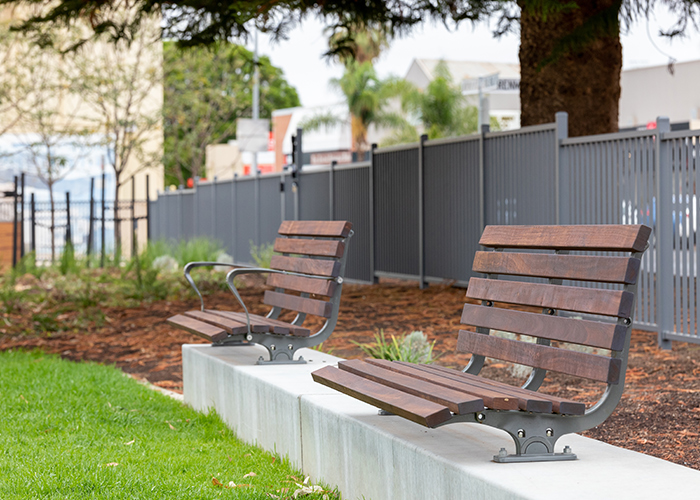 Plinth-mounted Mall DDA Seats with Jarrah battens and frames in tailored colour Metropolis Storm Pearl grey.