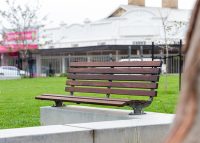 Plinth-mounted Mall DDA Seat with Jarrah battens and frames in tailored colour Metropolis Storm Pearl grey.