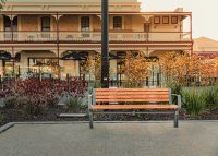 Aria Seat (CMA1, 1800mm) with aluminium woodgrain battens in Spotted Gum, and Sable Brilliance frame.