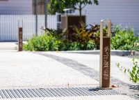 Linea Bollard (B6) with etched artwork, aluminium Bush Cherry insert, Textura Doe Skin frame.
