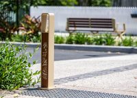 Linea Bollard (B6) with etched artwork, aluminium Bush Cherry insert, Textura Doe Skin frame.