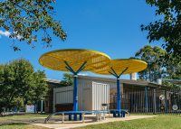 ChillOUT Tree (CT1) with Brilliant Yellow roof, trunk in Bondi Blue. Tailored Mall Curved Slim Bench.