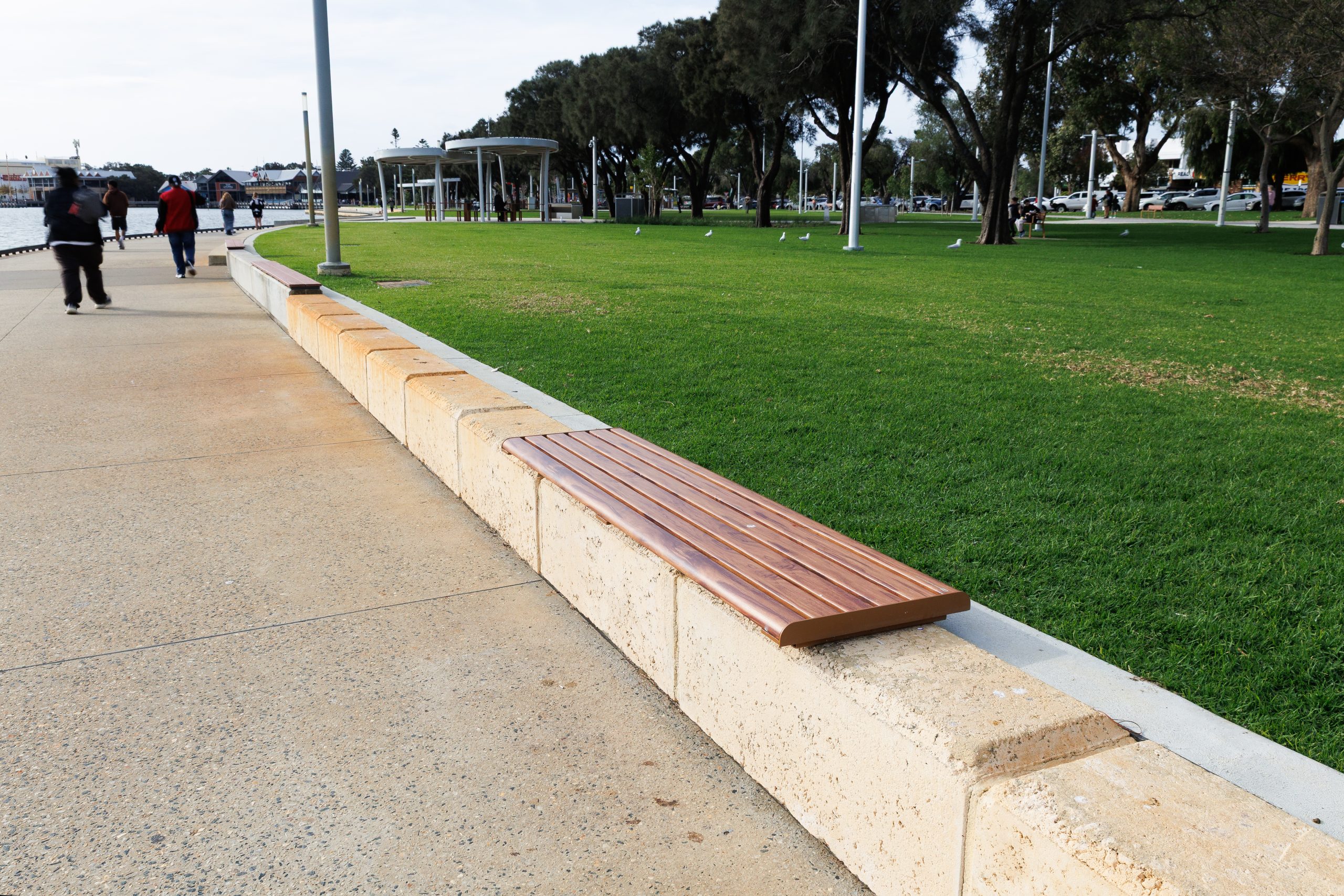 Linea Bench, plinth-fixed 2100mm, with aluminium woodgrain Spotted Gum battens, Textura Russet frames.