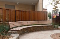 Linea Curved Seat (tailored radius, plinth-fixed) with aluminium Curly Birch battens and Textura Core Ten frames.