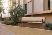 Linea Seat (2100mm, plinth-fixed) with arms, aluminium Curly Birch battens and Textura Core Ten frames.