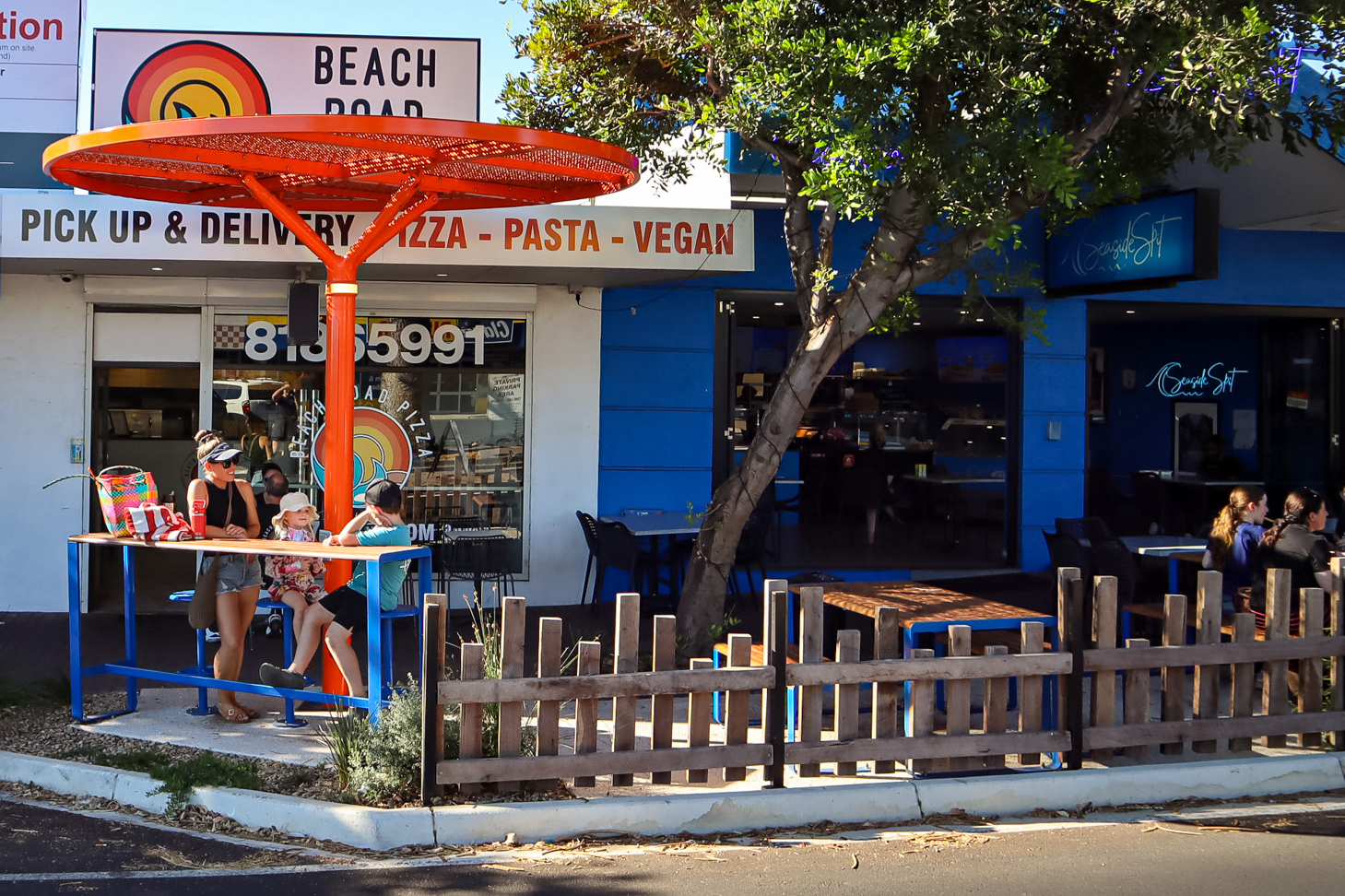 ChillOUT Tree (CT1) powered, in Sensation Orange. Linea Table, Bench and Lookout Bar Table with aluminium Spotted Gum battens, Jaybird Blue frames. Cafe Bar Stool in Jaybird Blue.
