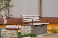 Linea Seat (2100mm, plinth-fixed) with arms, aluminium Curly Birch battens and Textura Core Ten frames.