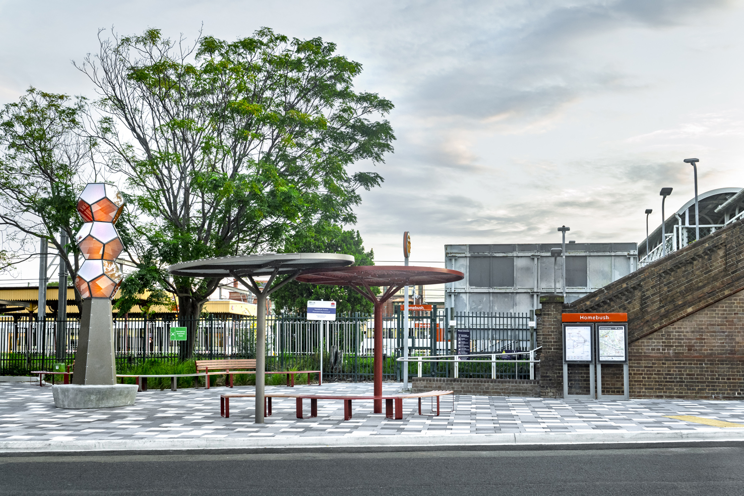 Linea Curved Seats and Benches with aluminium Spotted Gum battens, Pioneer Red frames. ChillOUT Trees in Textura Jasper and Pioneer Red.