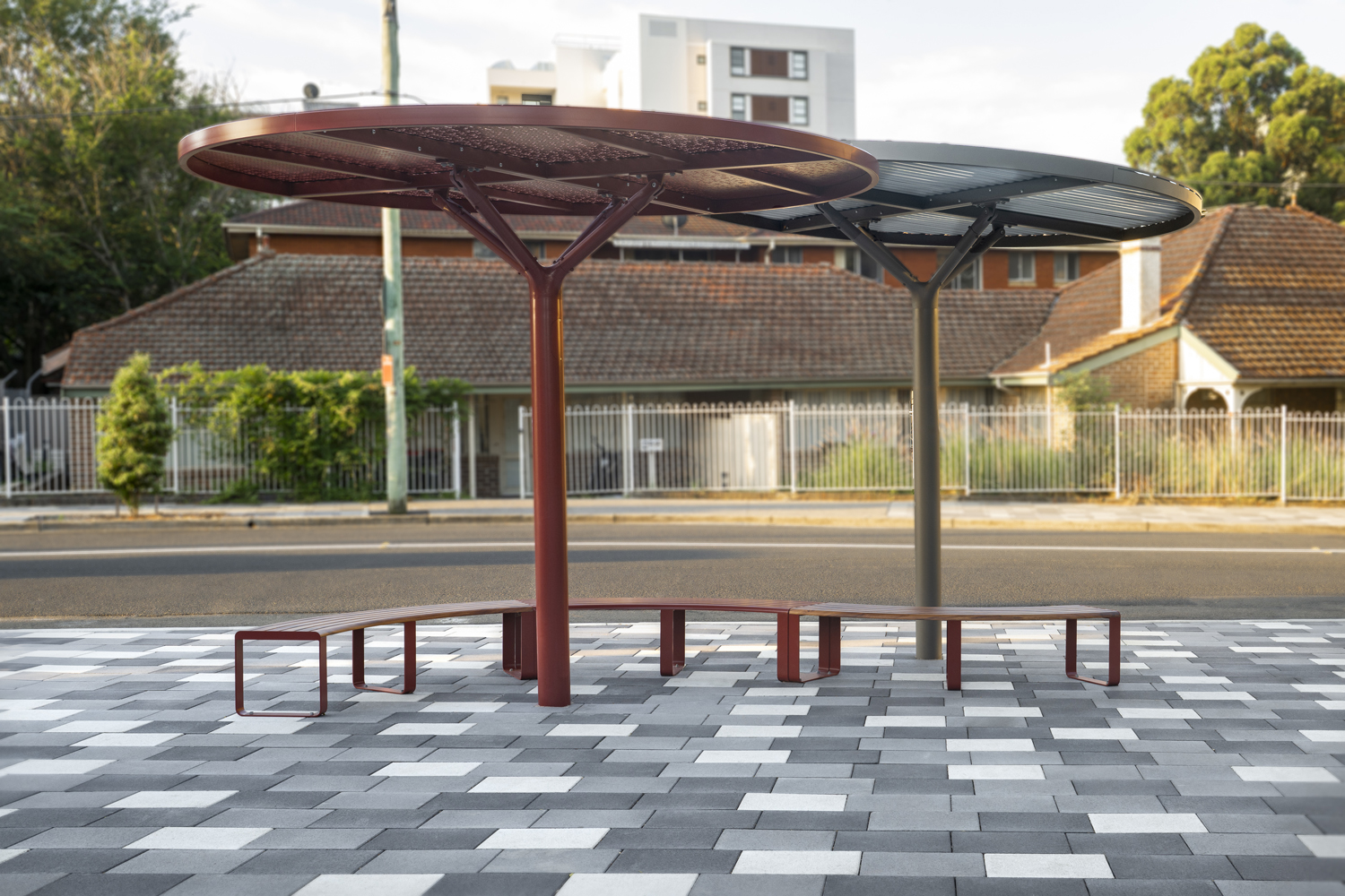 ChillOUT Tree in Pioneer Red with Champagne perforated roof, and Textura Jasper with solid Shale Grey roof. Linea Curved Benches with aluminium Spotted Gum battens, Pioneer Red frames.