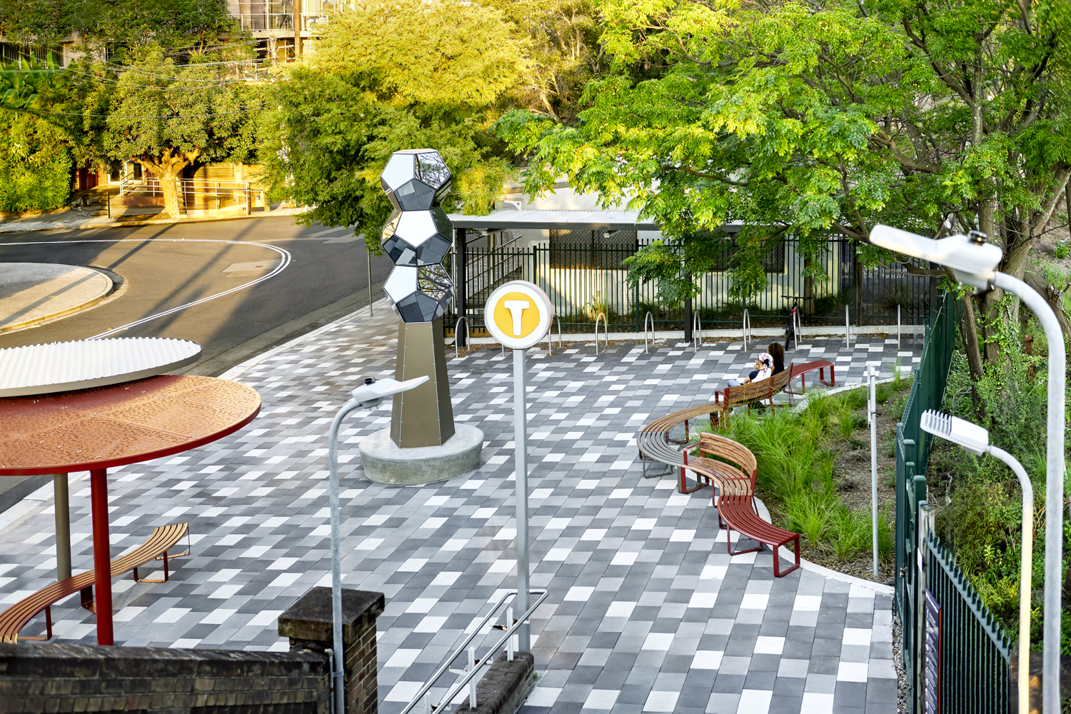 ChillOUT Tree, in Pioneer Red with Champagne perforated roof, and Textura Jasper with solid Shale Grey roof. Linea Curved Seats and Benches in aluminium Spotted Gum, Pioneer Red and Textura Jasper.